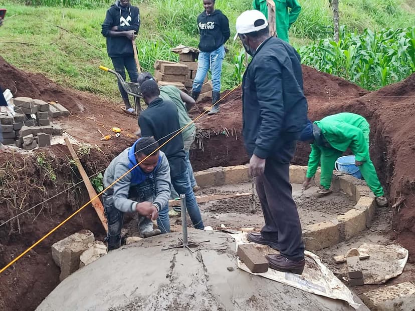 Team finishing the top of a digester dome, wider view